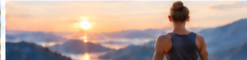 Woman sitting facing a mountain sunrise